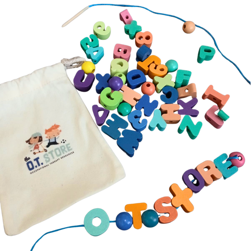 Colourful wooden letter and number beads scattered beside a drawstring bag with a blue string threaded through some beads spelling "OT store" on a white background.